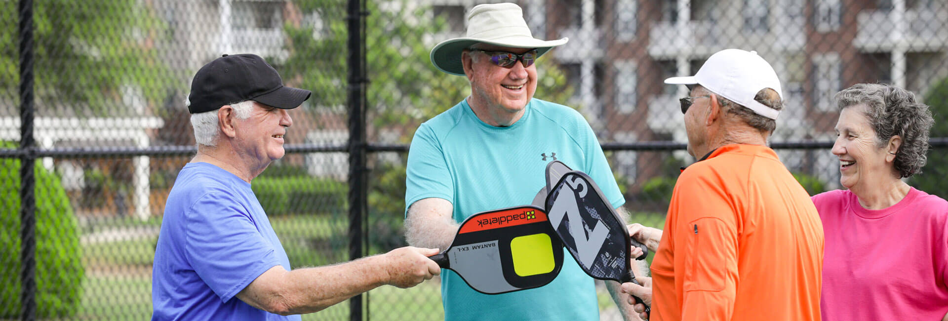 Group of friends touching rackets in preparation of their pickleball match.