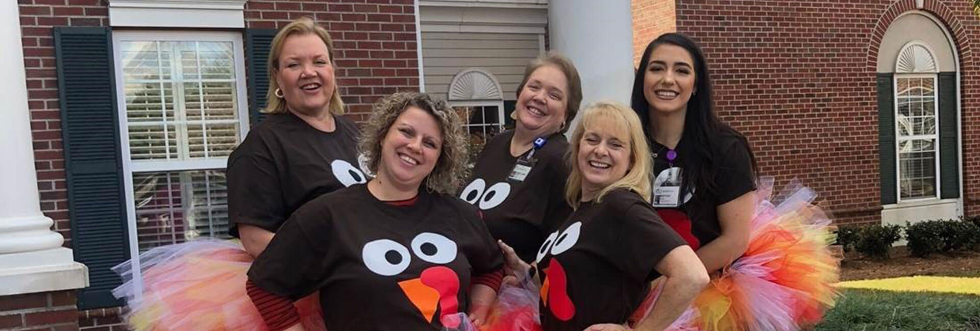 Carlyle Place team of employees dressed with turkey shirts and tutus.