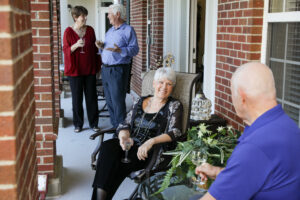 senior couples talk while visiting on a front porch
