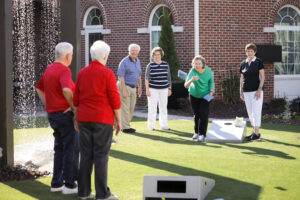 seniors play an outdoor game tossing bean bags